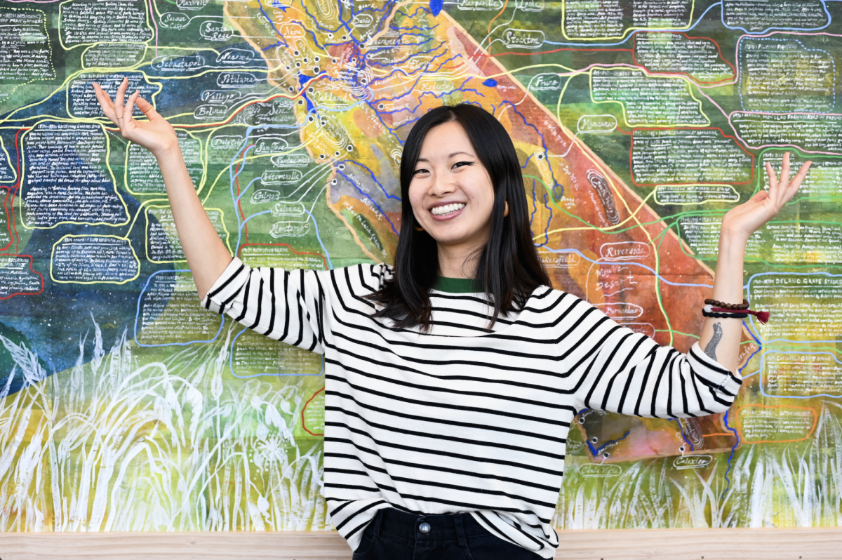 Zheng poses in front her map “How to Make a Golden State.” This map charts the labor of the Asian farmworkers who played a crucial role in shaping California’s agricultural infrastructure.